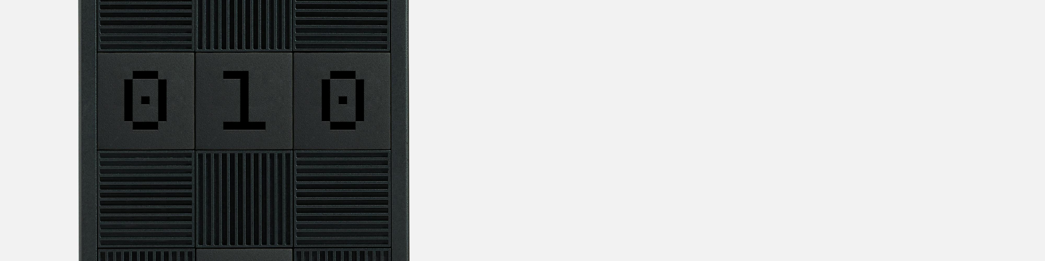 Middle third of a Framework Desktop, with three tiles with engravings 0,1 and 0 among other black tiles.