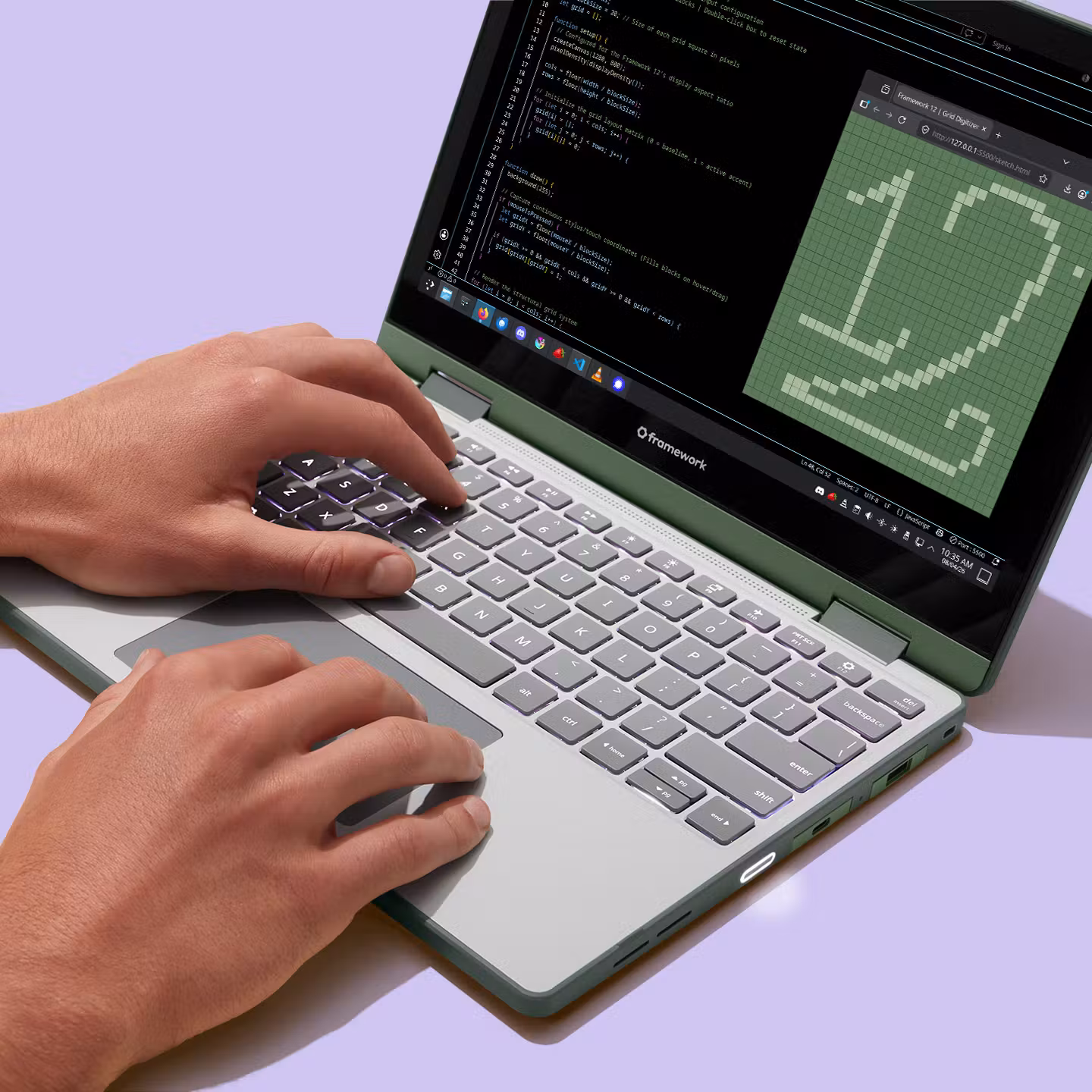 Close-up of two hands typing on the keyboard and trackpad of a Sage Framework Laptop 12..