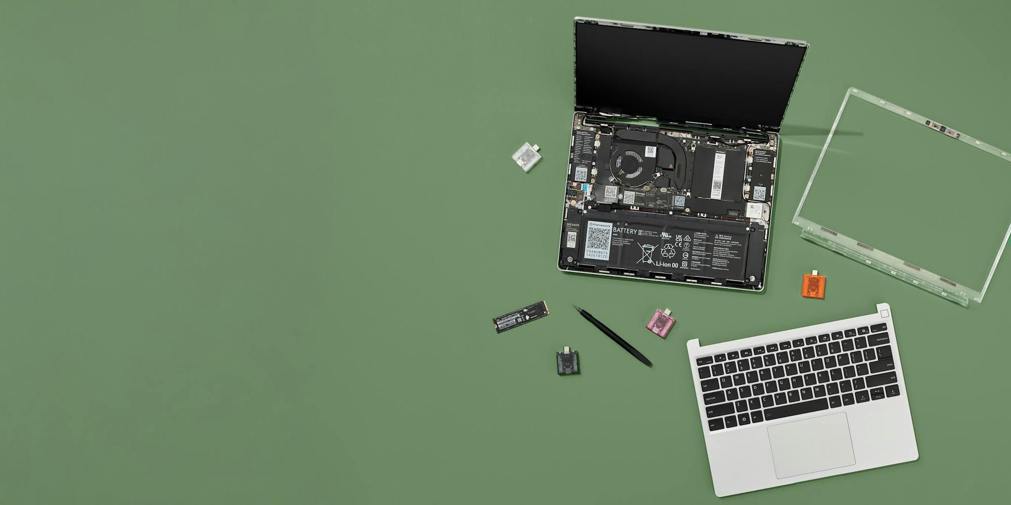 Framework Laptop 13 opened up, parts and screwdriver beside it