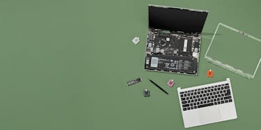 Framework Laptop 13 with bezel and top cover removed, exposing internals with Expansion Cards, screws and screwdriver beside it.