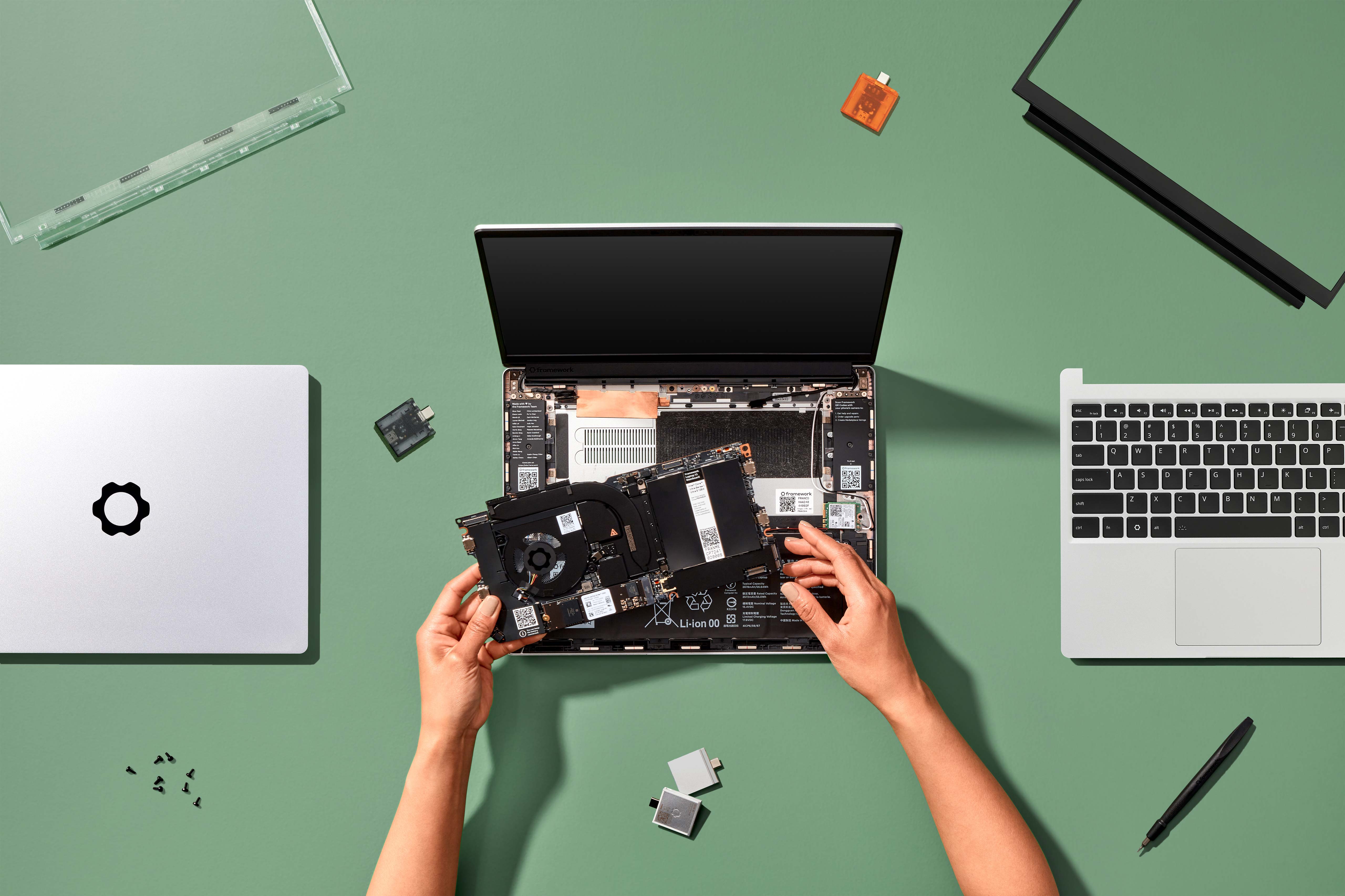 Hands placing a Framework Laptop 13 Mainboard into a Framework Laptop 13