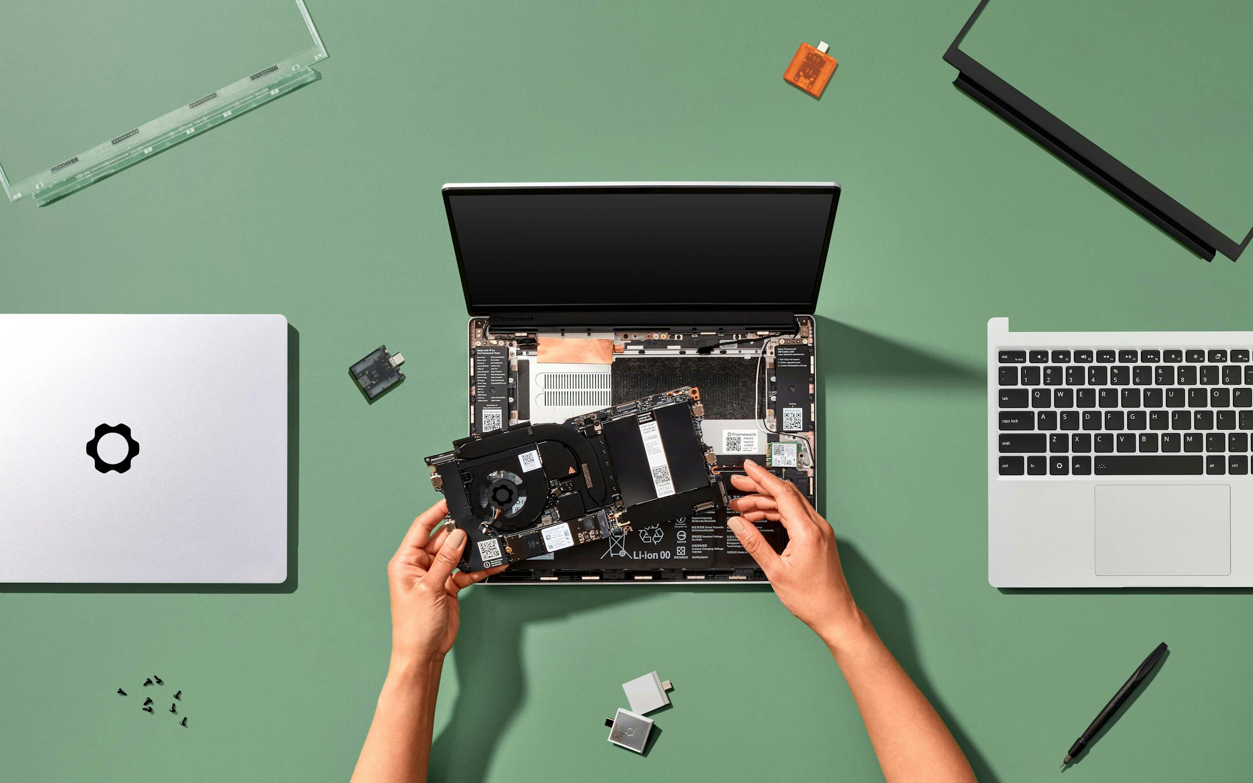Hands placing a Framework Laptop 13 Mainboard into a Framework Laptop 13