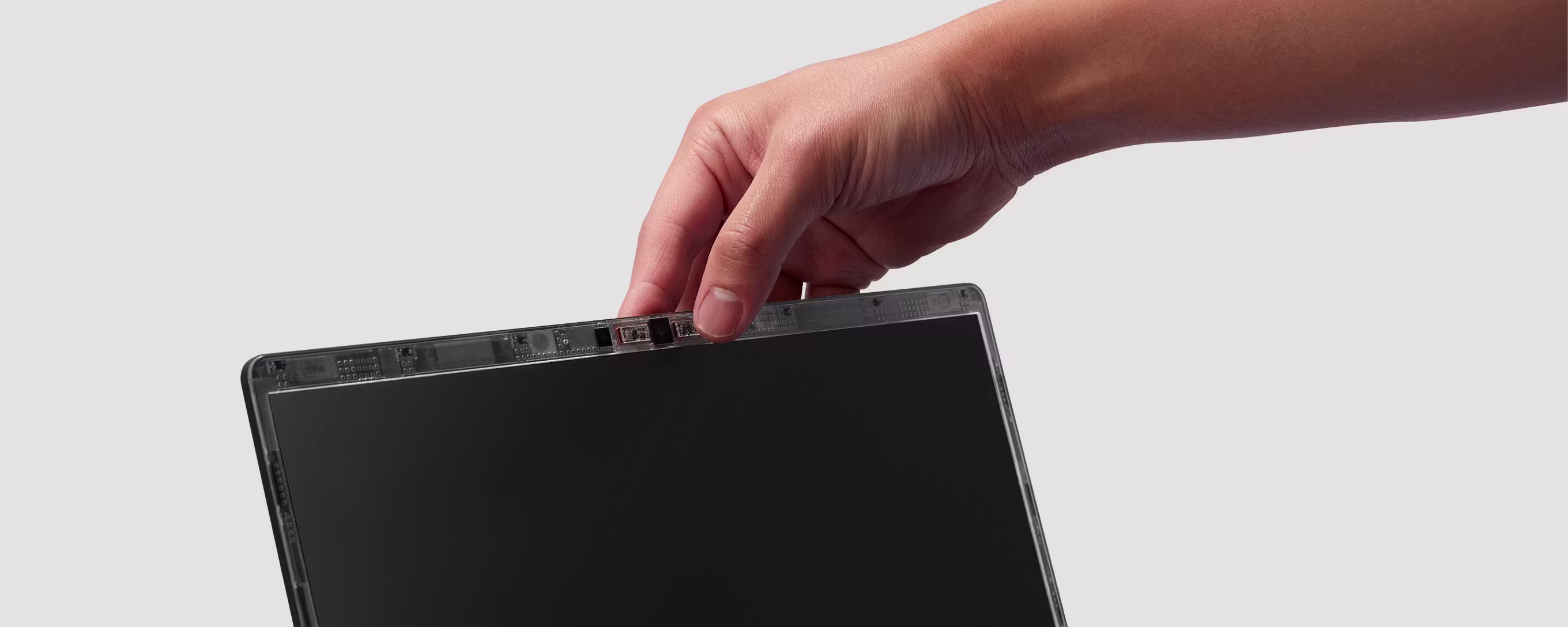 A tight close-up of the camera module on Framework Laptop 13 Pro with a hand turning the privacy switch off.