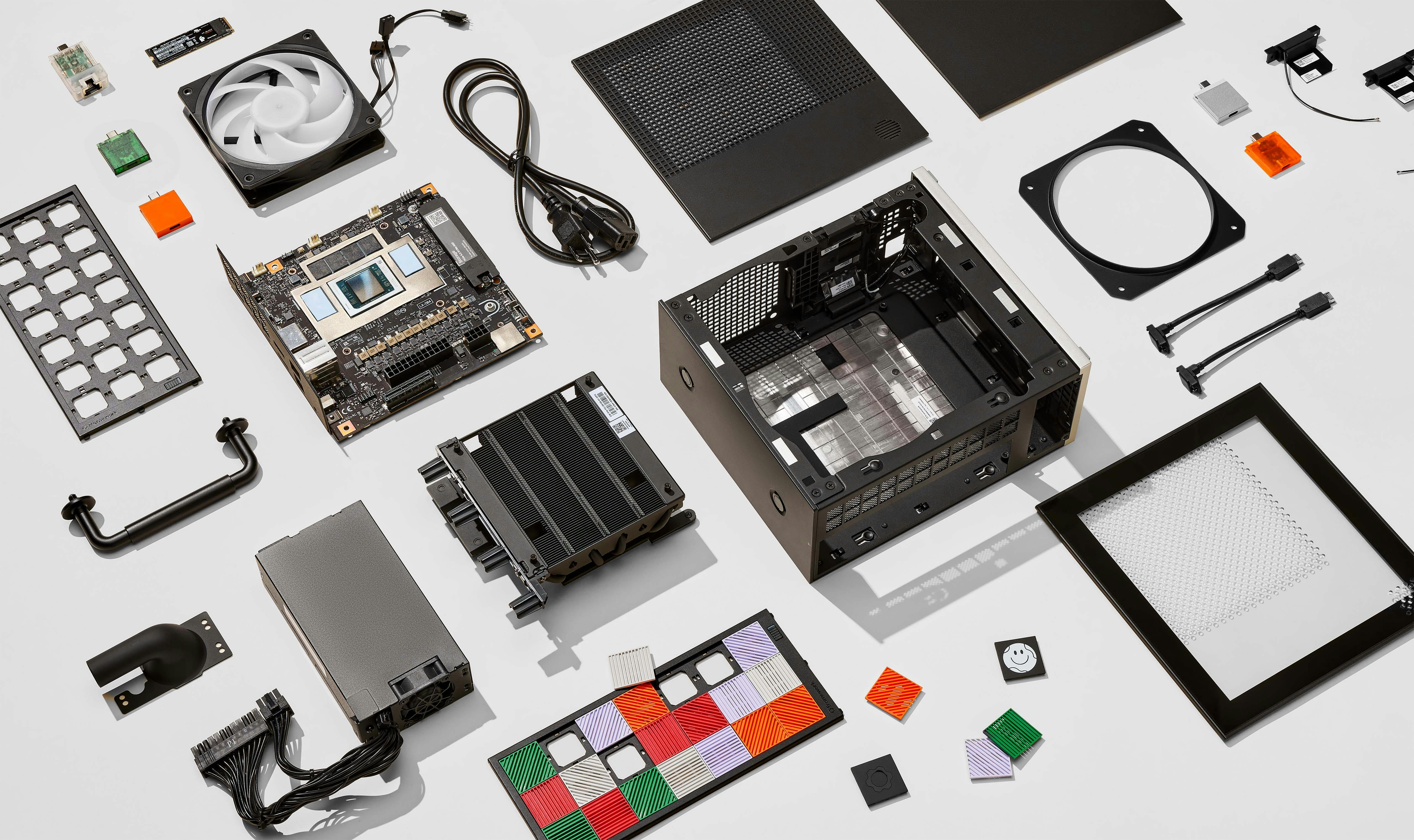An overhead, knolling-style flat lay photography shot of a disassembled Framework desktop chassis and its modular components.